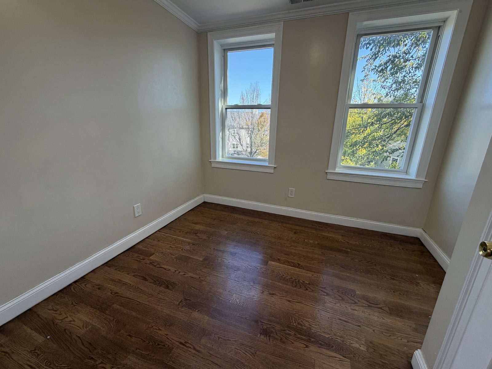 Room with two windows and hardwood floors