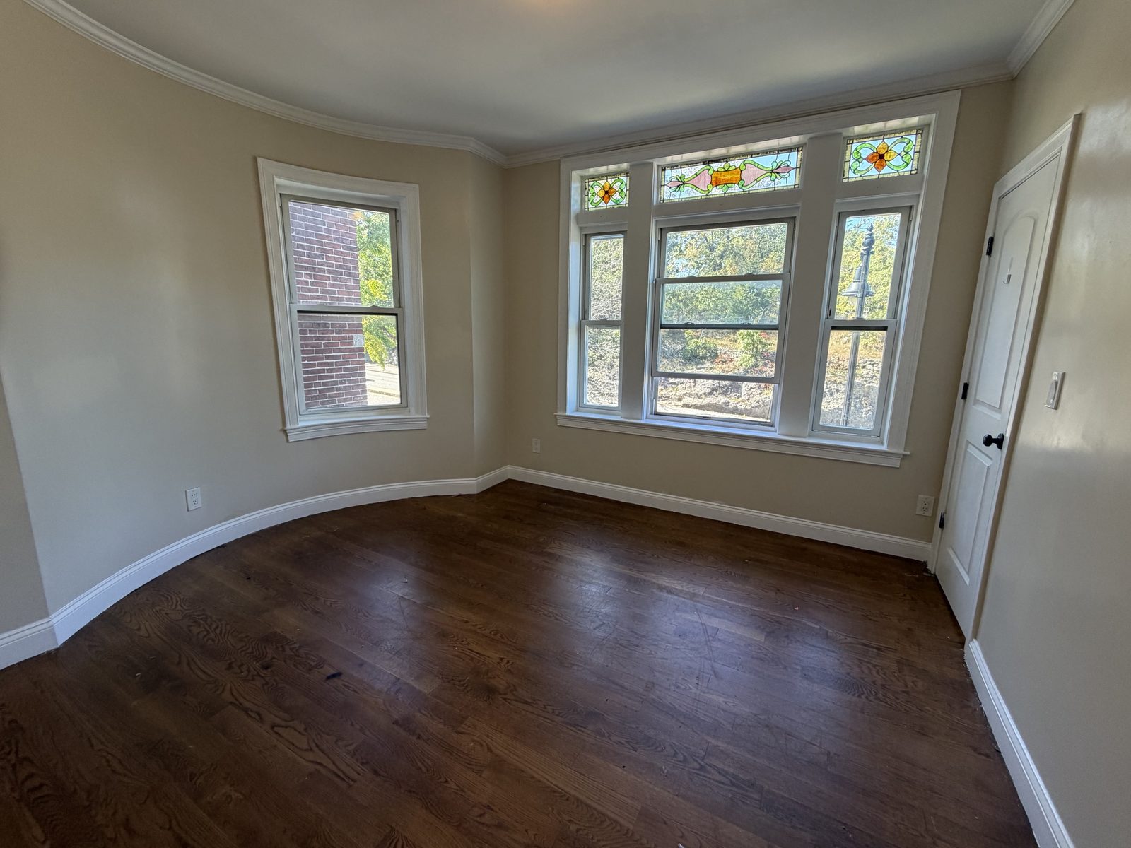 Sunny room with stained glass windows and curved wall at 56 Seaver Street