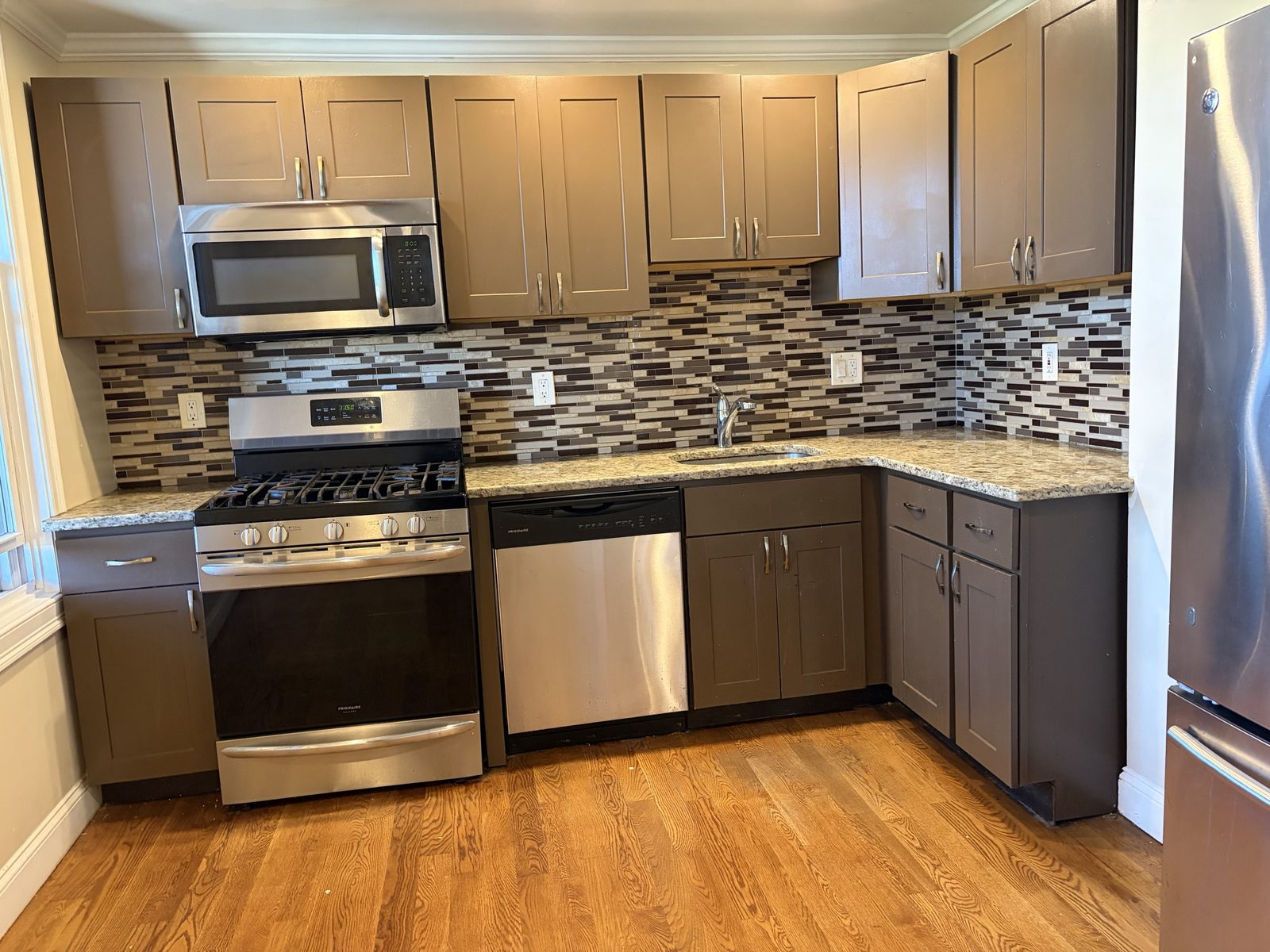 Kitchen with granite counters, tile backsplash and stainless appliances