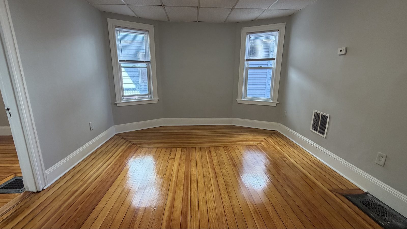 Bedroom with two windows and hardwood floors